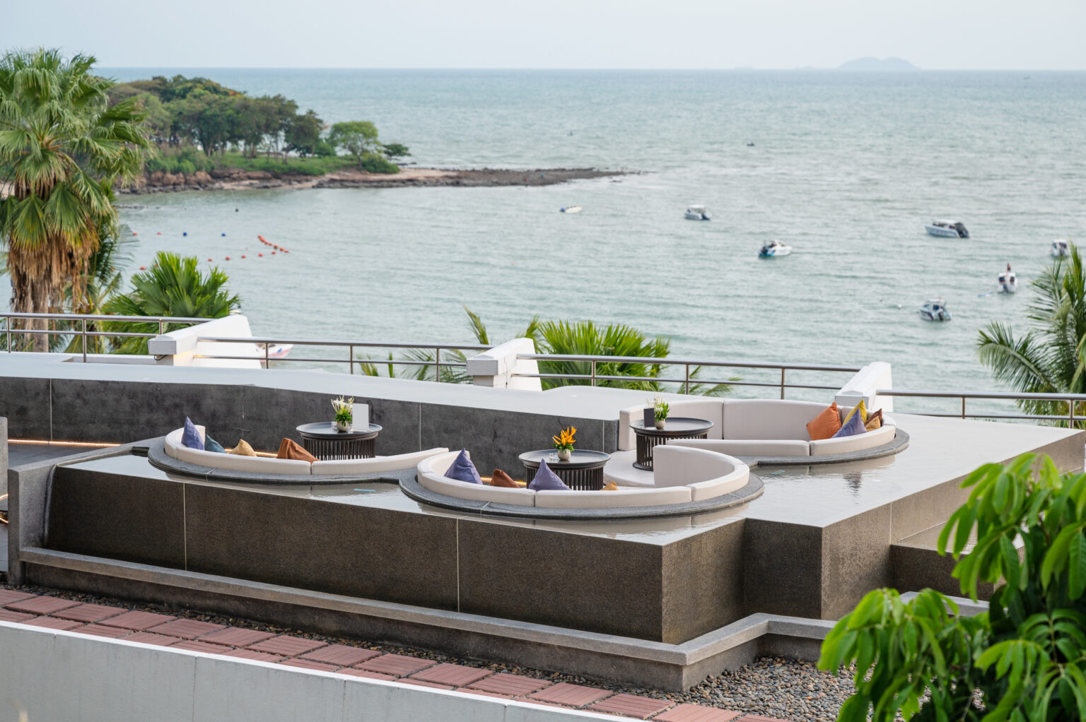 Dining table with rounded sofa on balcony with sea view at restaurant